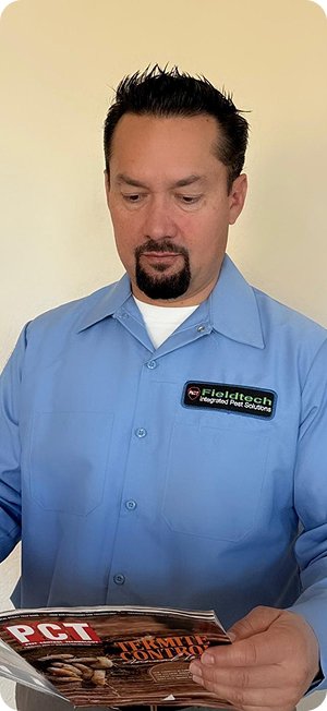 Fieldtech owner Nelson reading a PCT pest control trade magazine showing his ongoing professional development and industry expertise