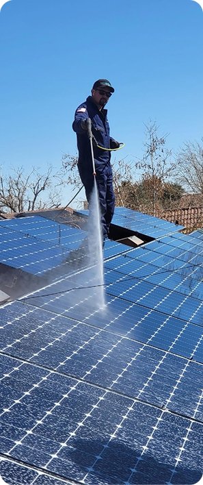 Pest control technician standing on a rooftop solar panel array performing a solar panel pest exclusion or cleaning service in California